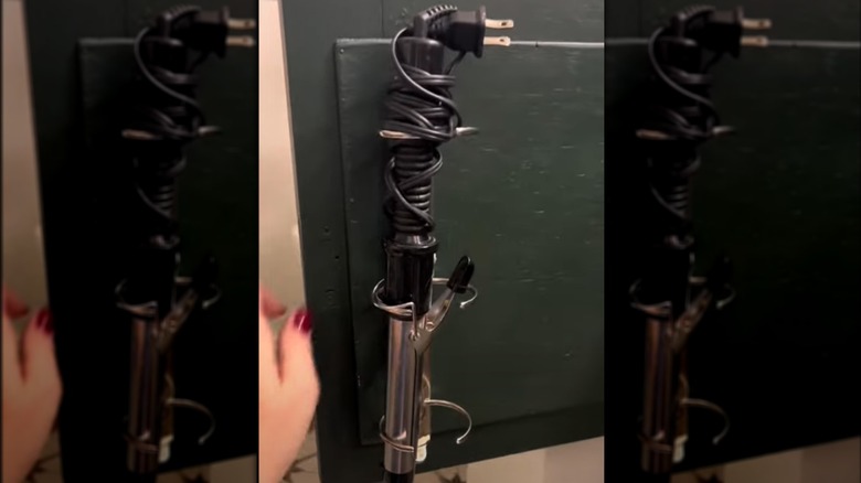 open cabinet door with curling iron set in a binder spine