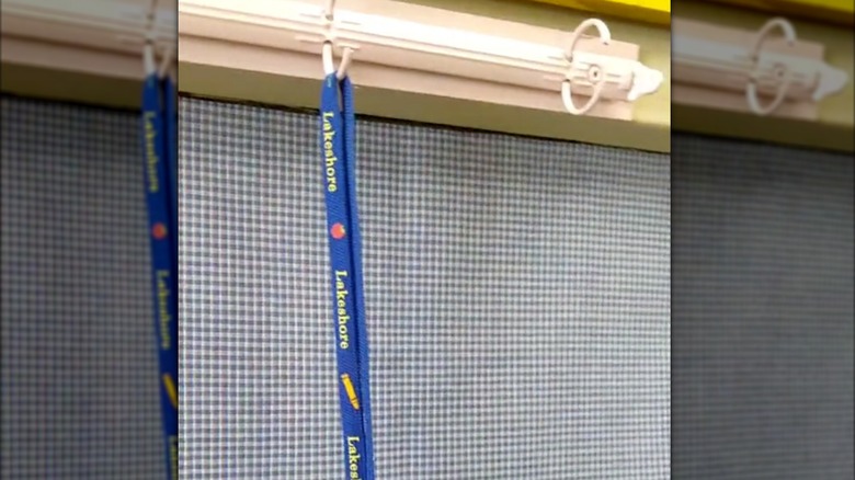 blue lanyard hanging on metal binder spine