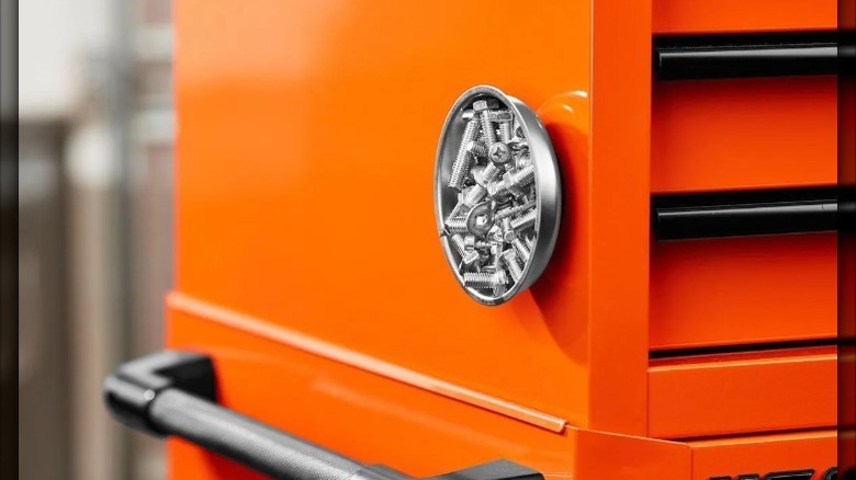 screws bonded to inside of storage disk secured on side of storage cabinet