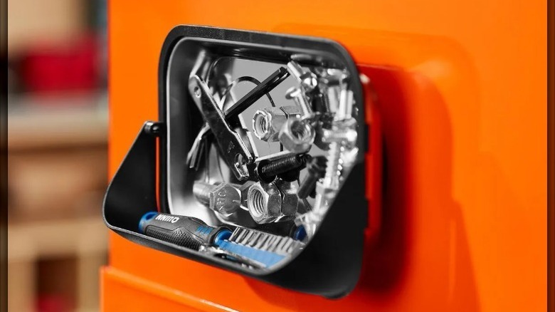 closeup on magnetic parts tray with hood holding bolts and screw driver