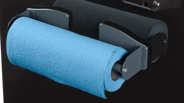 closeup on blue paper towels in magnetic holder on black reflective surface