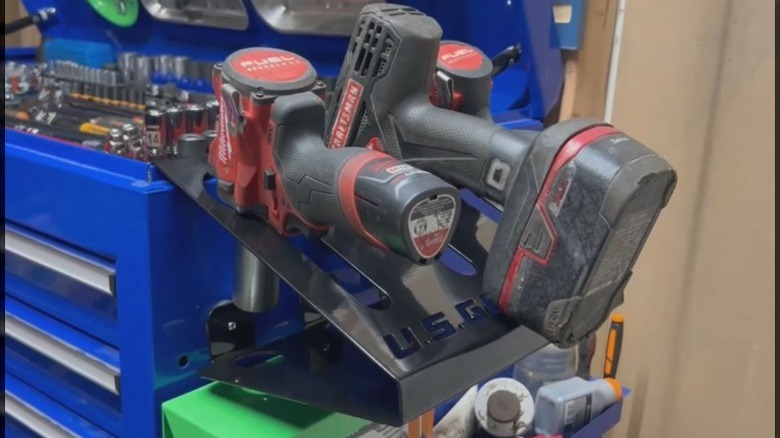 Magnetic power and air tool holder holding drills and other tools on cabinet