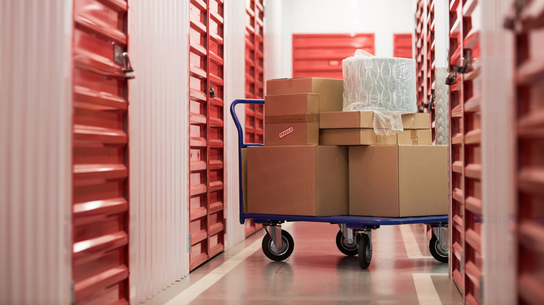 Cart with cardboard boxes in corridor of self-storage