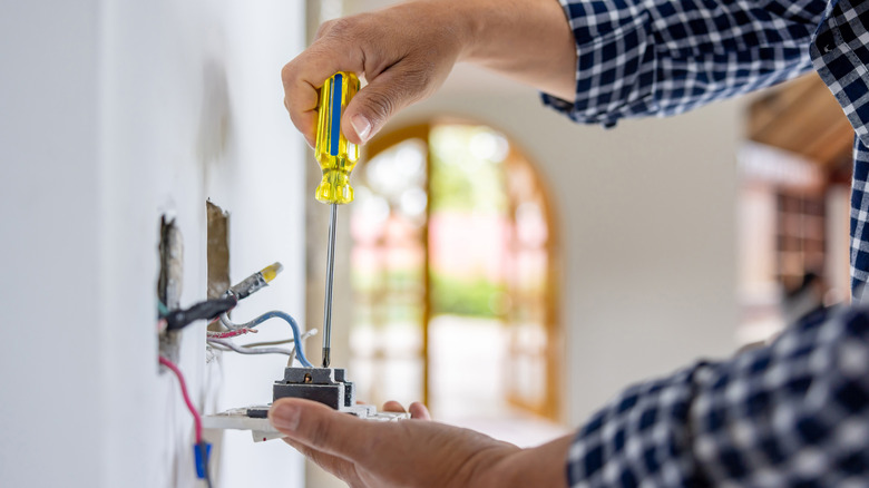 Close-up on an electrician installing a power outlet