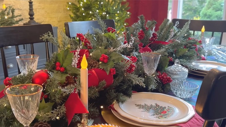 Evergreen centerpiece made with two small Christmas trees, ornaments, bows, and picks