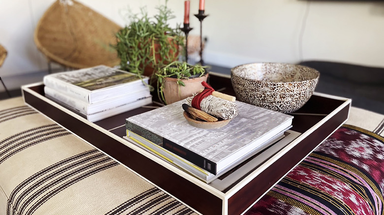 Coffee books being used as decor on ottoman