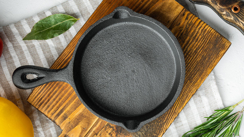 Empty cast iron pan on a wooden cutting board