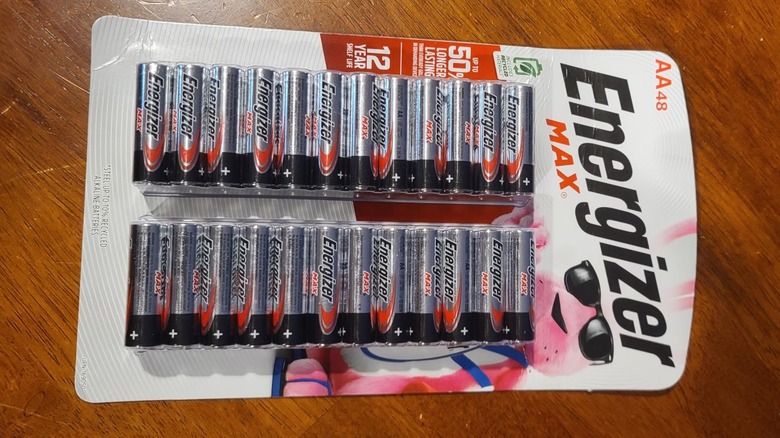 Packaged AA Energizer batteries on scratched wood countertop