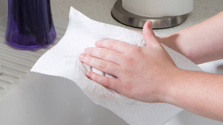 Man's hand soaking up moisture with Sam's Club paper towel