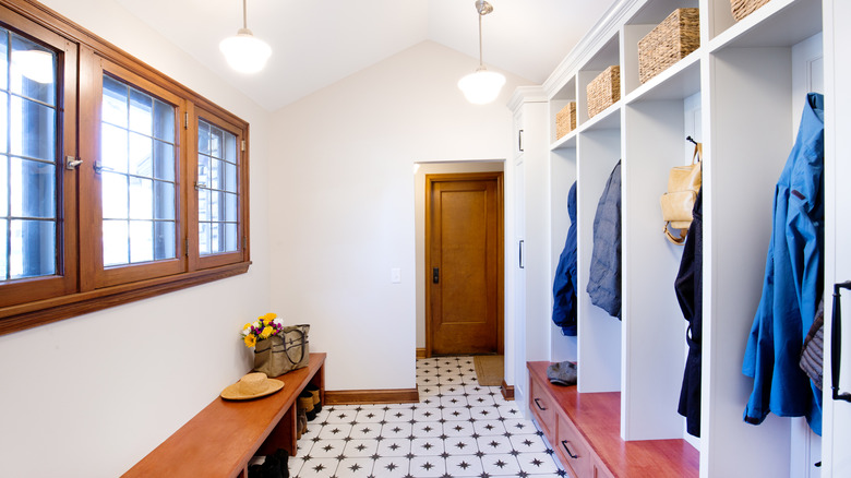 A white mudroom with built-in storage and hanging