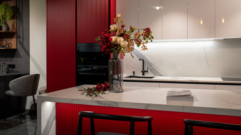 Kitchen with red cabinets and marble counters