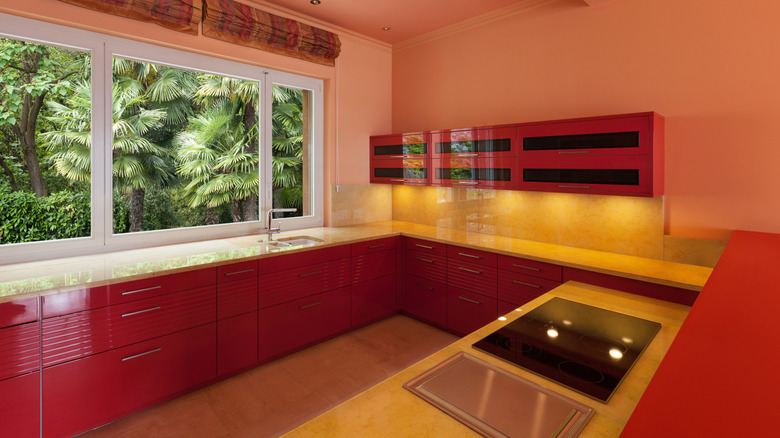 Kitchen with red cabinets and light counters and cabinets