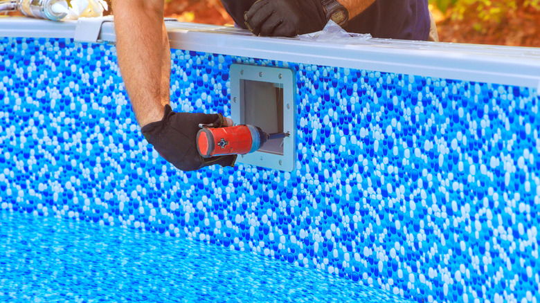 Worker installing an efficient pool filtration system