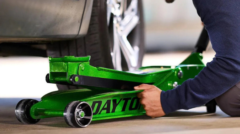 A green Daytona floor jack being used in a garage