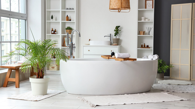 A large white bathtub in the middle of a white bathroom