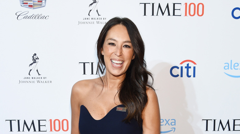 Joanna Gaines wearing a black long gown and smiling on a red carpet