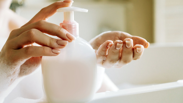 Person putting soap on hands from soap dispenser