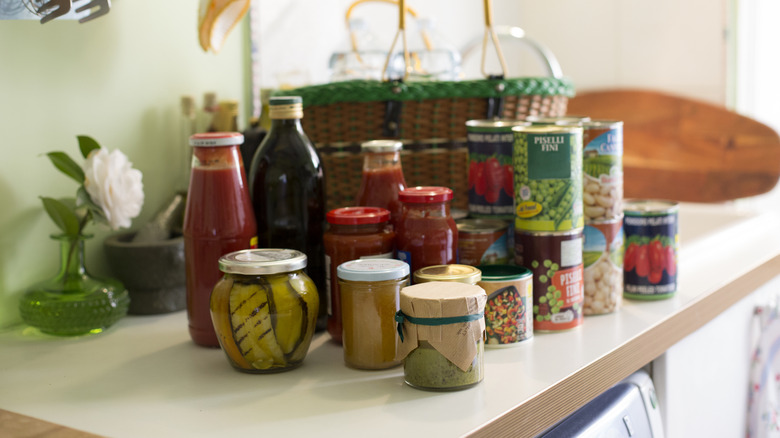 Canned food items on a table near a woven basket