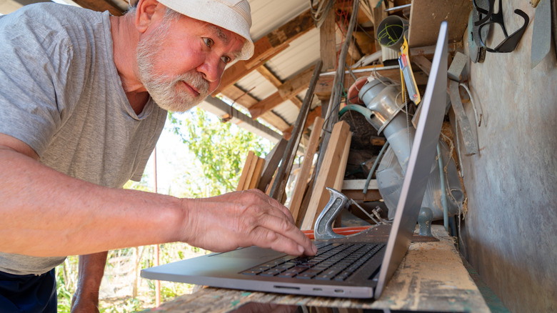 Man using a laptop inside a shed