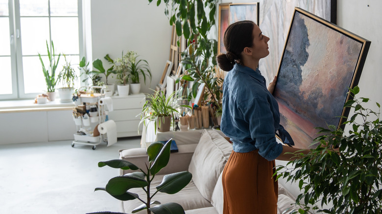 Woman holding a painting in her hands