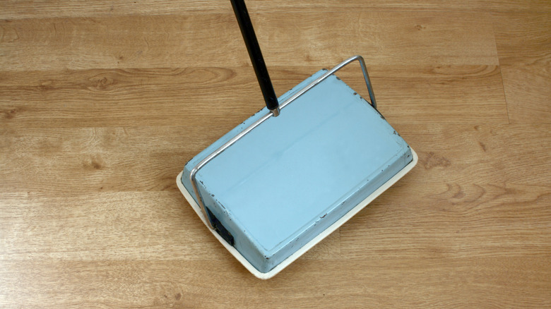 blue carpet sweeper on hardwood floor