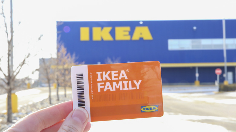 Person holding an IKEA family card up in front of a store