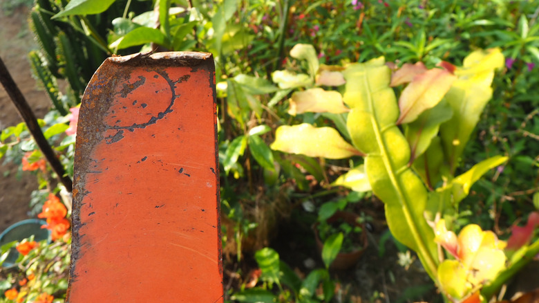 Lawn mower on its side to showcase its bent blade