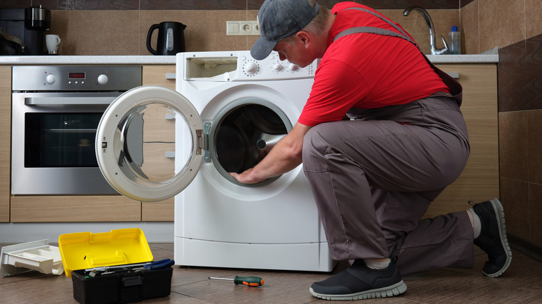technician looking at washer