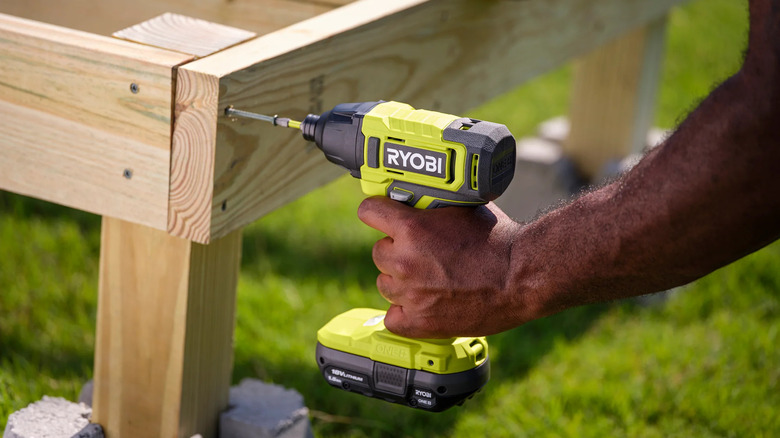 A person assembling a wooden frame with Ryobi's 18V One+ Cordless ¼-inch Impact Driver