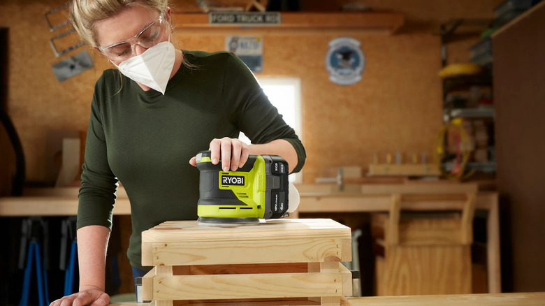 A person sanding wood with Ryobi's 18V One+ Cordless 5-inch Random Orbit Sander