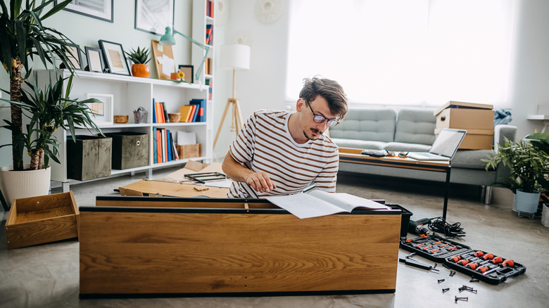 Man looking at instructions to assemble a cabinet