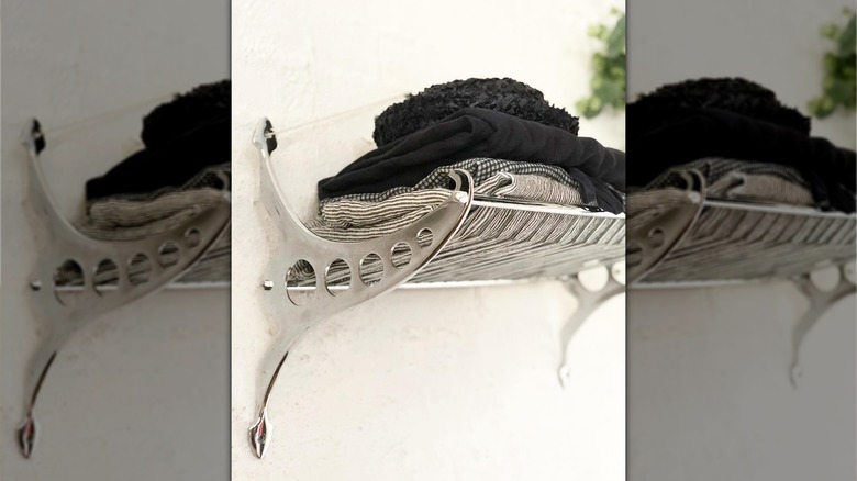 vintage luggage rack on bathroom wall holding towels