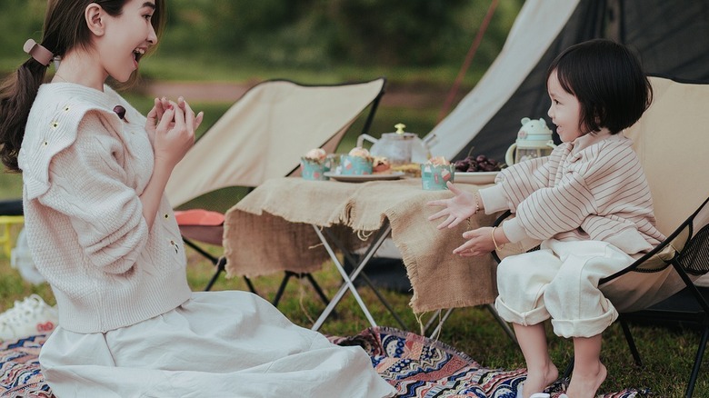mom and daughter outside playing with table with treats