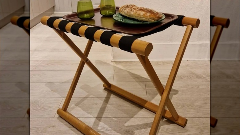 luggage rack with tray on top with glasses and food