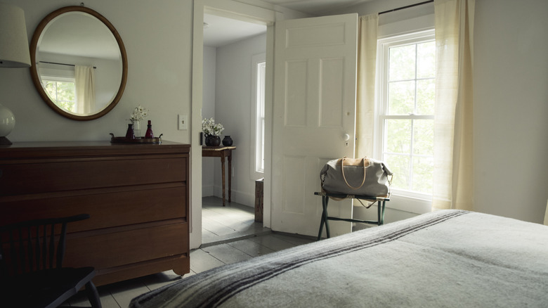 guest bedroom with open door and luggage rack and dresser