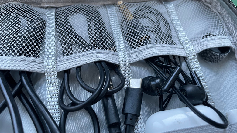 Charging cables and earbuds in a netted storage organizer case