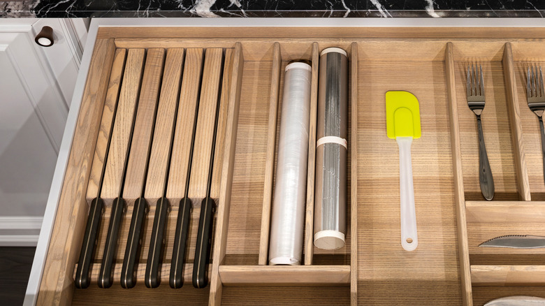 Kitchen drawer with built-in knife block as well as slots for cutlery and cling film
