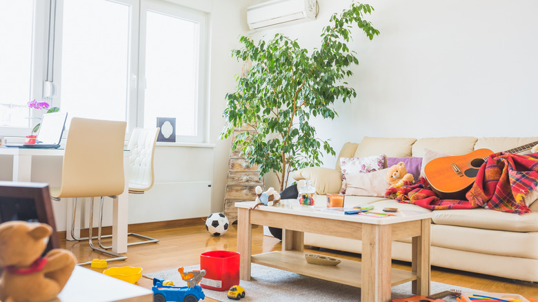 Living room with couch and coffee table covered in toys and clutter
