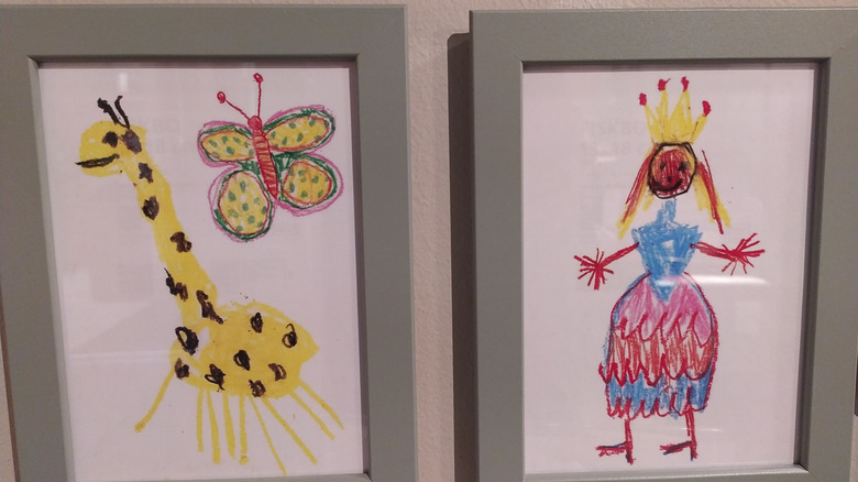 Children's drawings framed on wall