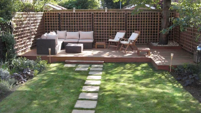 a square wood trellis with square paver path