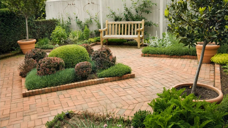 a square shaped bed in a brick patio courtyard