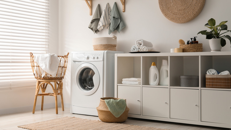 A washing machine, towels and detergents in laundry room