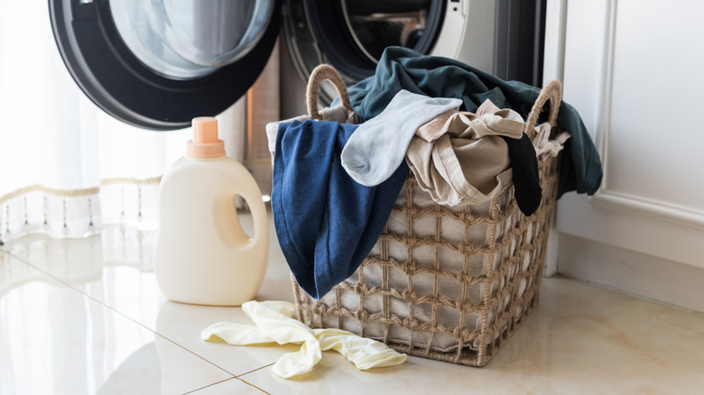 Dirty clothes on a hamper, about to be thrown in the washing machine