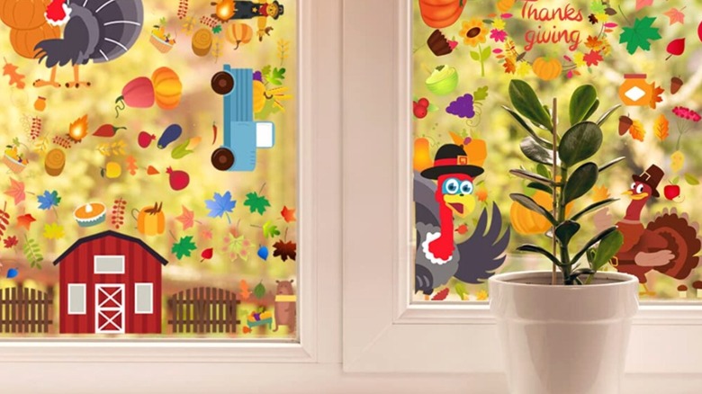 A window filled with Thanksgiving-themed stickers including turkeys, pumpkins, and produce