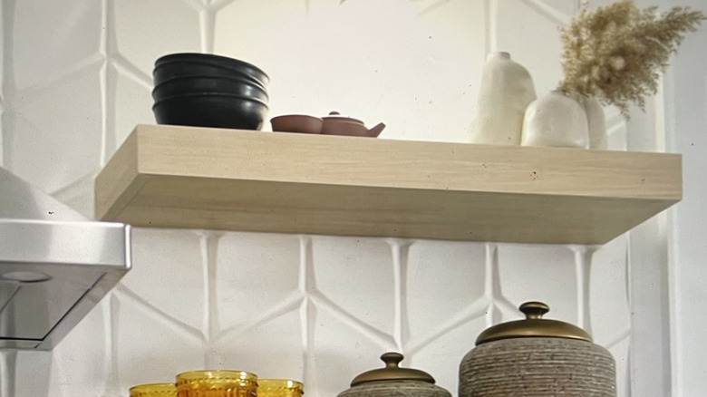 3D kitchen backsplash in white tile with a rhombus molded relief pattern and floating shelves