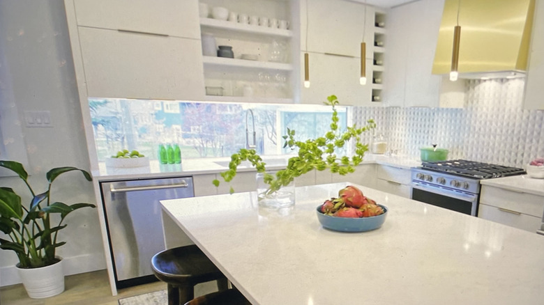 Modern white kitchen with narrow window used as backsplash to kitchen counter