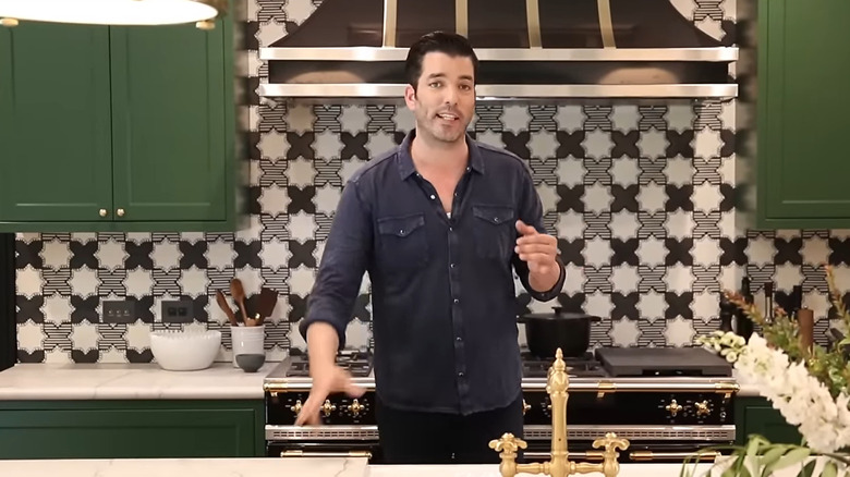 Jonathan Scott talking in front of his geometric kitchen backsplash