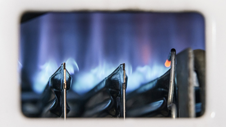 A view of blue flames through the window of a gas boiler