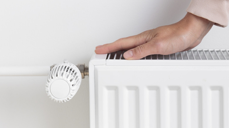 Close up of a person's hand placed on a radiator