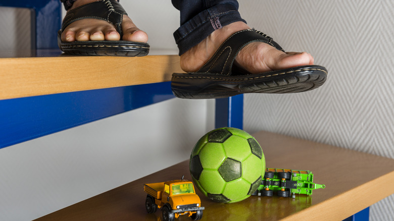 Person wearing sandals about to step on toys left on the stairs